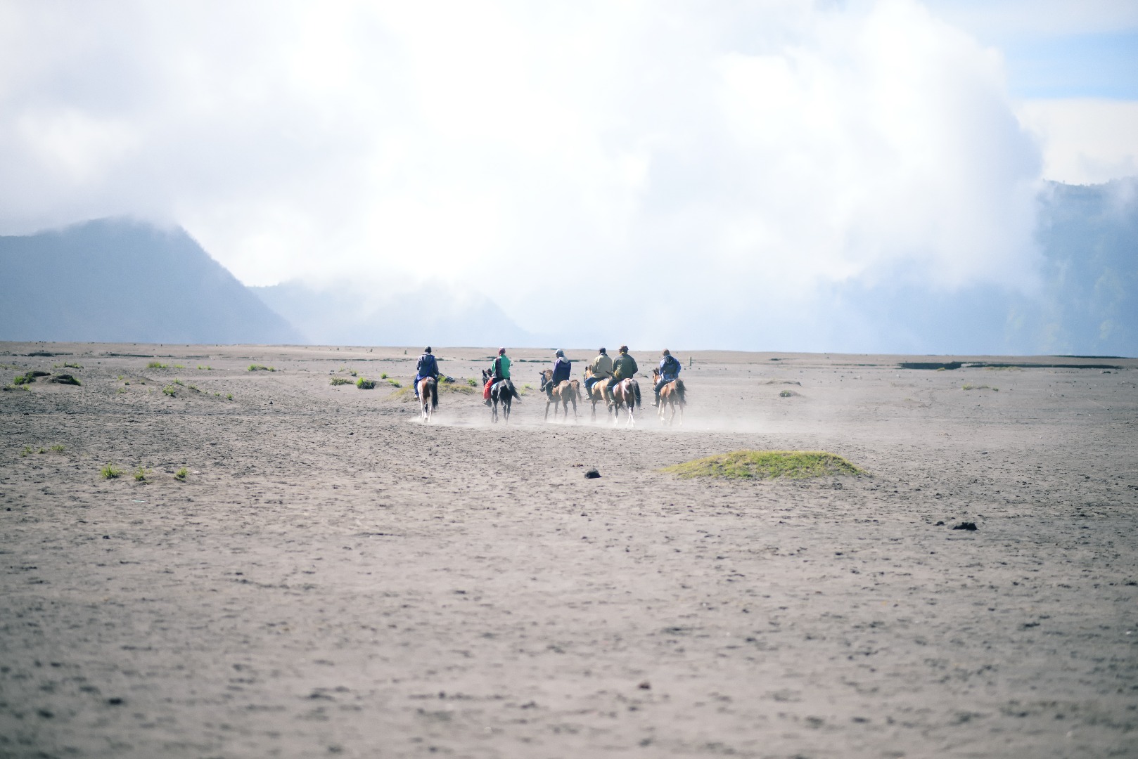 A group of riders on horseback in the desert against the background of a mountain.jpg